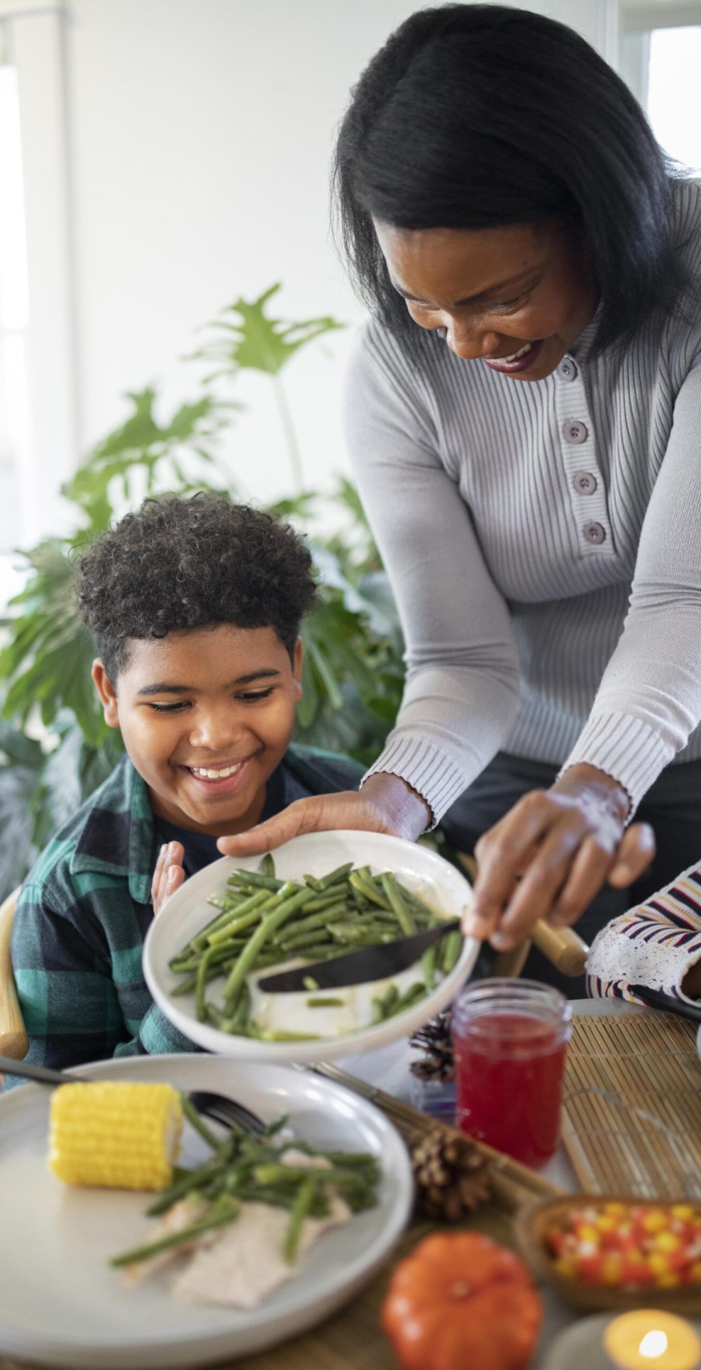 mother-putting-thanksgiving-day-food-her-son mother-putting-thanksgiving-day-food-her-son